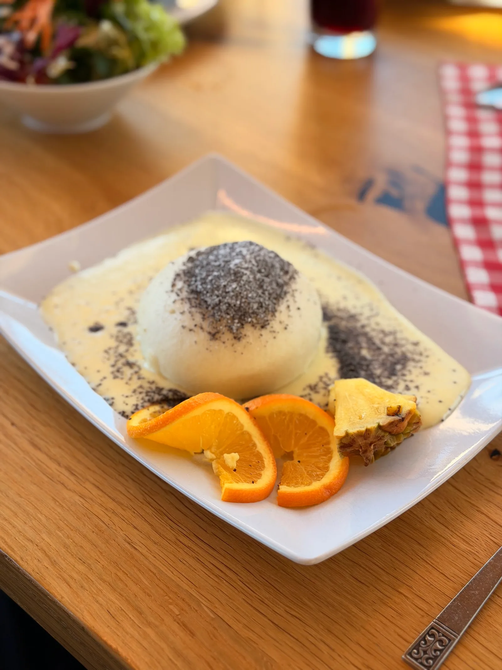 Germknödel mit Mohn und Puderzucker, garniert mit Orangenspalten