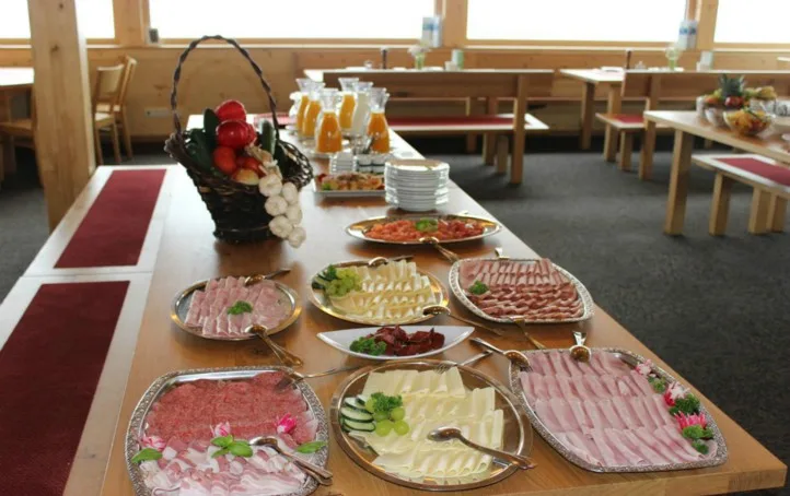 Das Frühstücksbuffet auf einer langen Tafel: Wurst- und Käseplatten, Brotkorb und Säfte